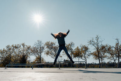 Woman jumping in mid-air against clear sky