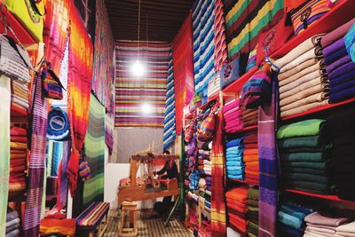 Worker working at workshop amidst multi colored fabrics