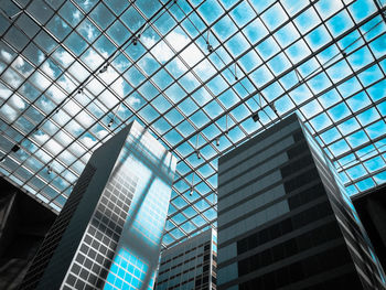 Low angle view of modern glass building against sky