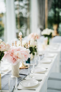 White long set wedding dinner table with decoration candlestick, glasses, and flowers. selective foc