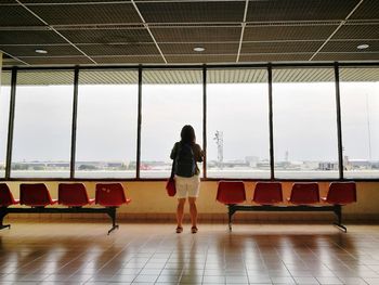 Rear view of woman standing at airport