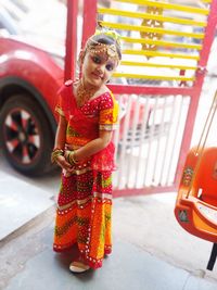 Woman standing by red car