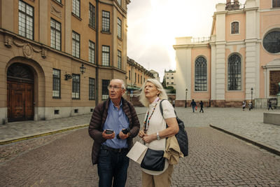 Confused senior couple standing on street in city