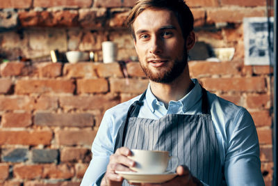 Portrait of young barista at cafe