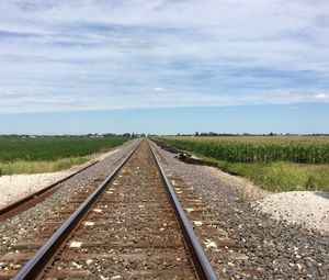 View of railroad tracks on field against sky