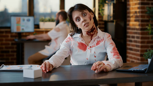 Portrait of businesswoman in zombie character at office