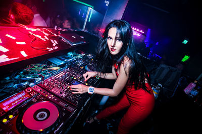 Portrait of woman playing dj in club
