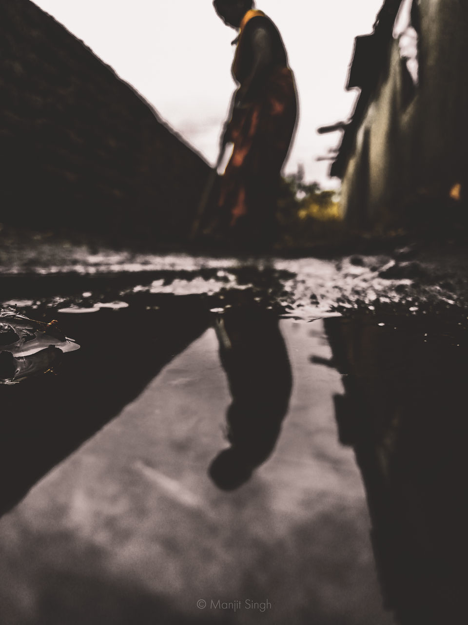 SHADOW OF PERSON WALKING ON STREET AGAINST SKY
