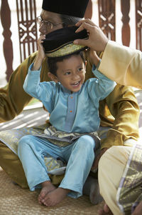 Boy with grandfather sitting on mat