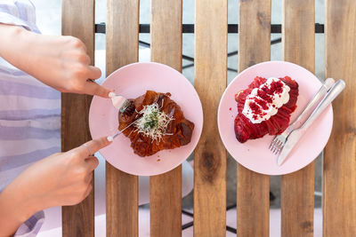 Cropped hands of woman holding food on table