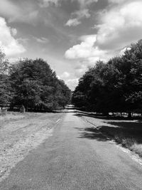 Empty road with trees in background