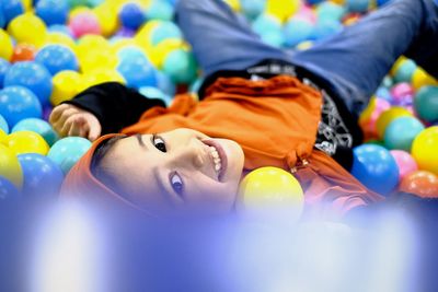 Portrait of smiling girl in multi colored ball pool