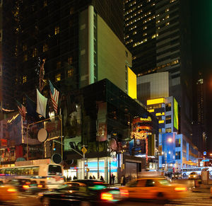 Illuminated city street and buildings at night