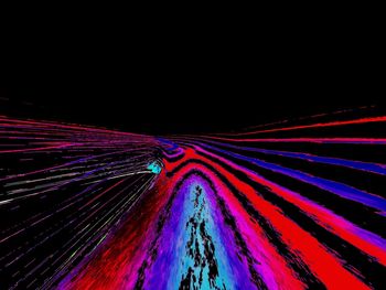 Low angle view of light trails against sky at night