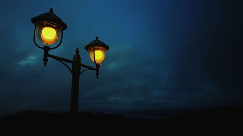 Low angle view of illuminated street light against sky at night