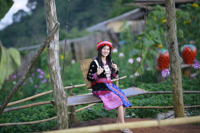 Portrait of woman sitting against plants