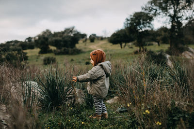 Rear view of woman standing on field