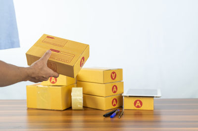 Cropped hand of woman holding toy blocks on table