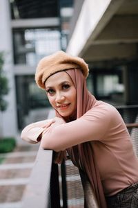 Portrait of woman leaning on railing