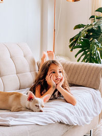 Portrait of young woman sitting on sofa at home