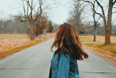 Rear view of woman on bare tree