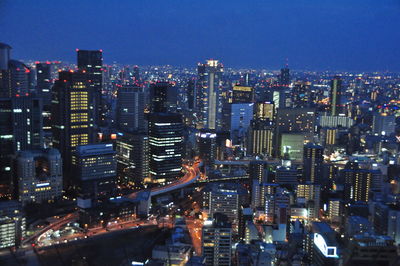 High angle view of illuminated cityscape against sky at night