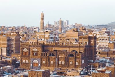 Buildings in city against clear sky