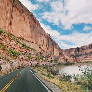 Road leading towards mountains against sky