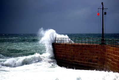 Sea waves splashing on retaining wall 