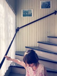 Girl sitting on steps at home