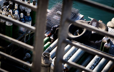 High angle view of metal fence oxygen bottles and worker 