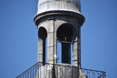 Low angle view of water tower against clear blue sky