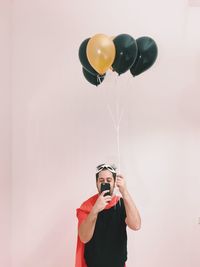 Portrait of young man with balloons