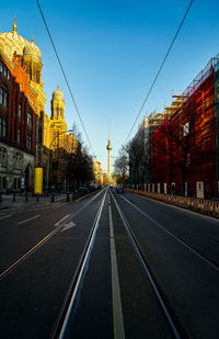 Road by buildings against sky in city