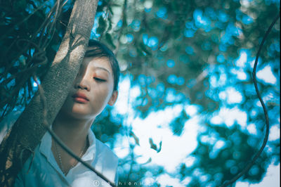 Portrait of young woman in tree trunk