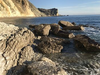 Rocks on beach against sky