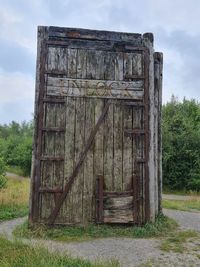 Old wooden structure on field against sky