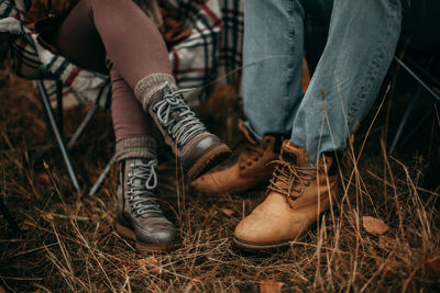 Legs of a loving couple in boots in autumn