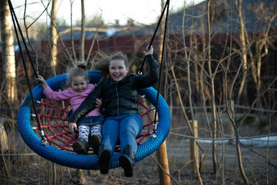 2 girls swinging on a swing