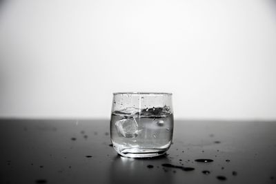 Close-up of glass on table against white background