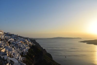 Scenic view of sea and buildings against clear sky