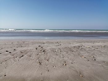 Scenic view of beach against clear blue sky