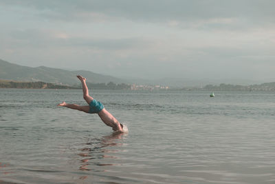 Man surfing in sea against sky