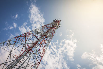 Telecommunication and cellular or radio antenna tower in blue sky with flare light