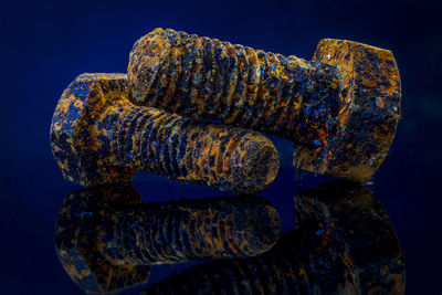 Close-up of rusty bolts on blue background