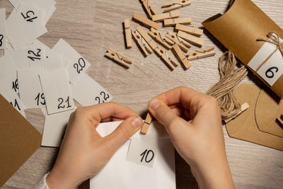 Cropped hands of person holding text on table