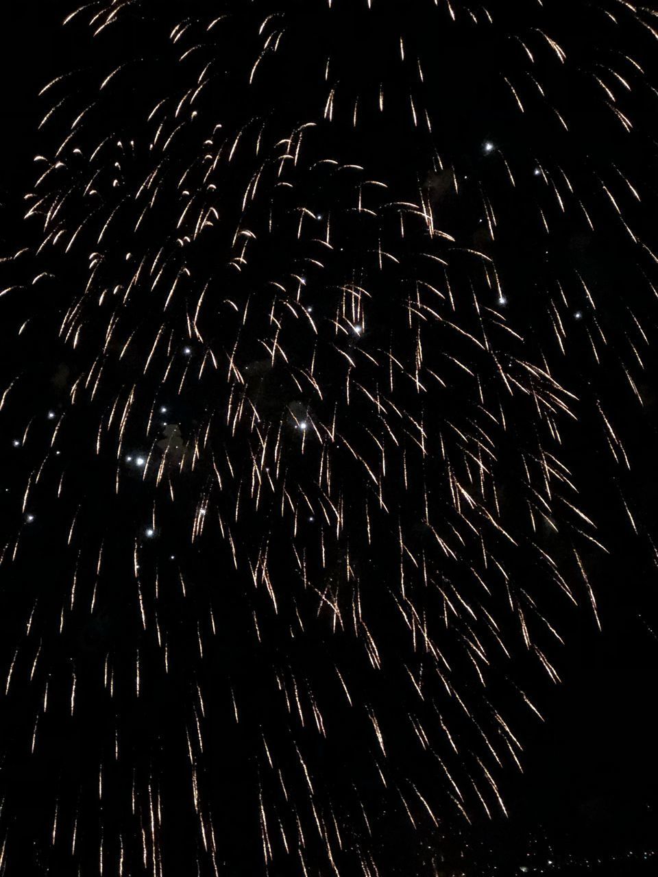 LOW ANGLE VIEW OF FIREWORKS AT NIGHT