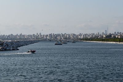 Scenic view of sea by buildings against sky