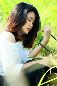 Beautiful young woman sitting on grass