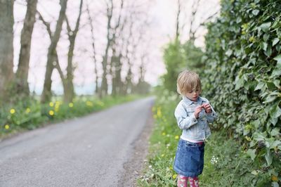 Full length of girl standing by tree